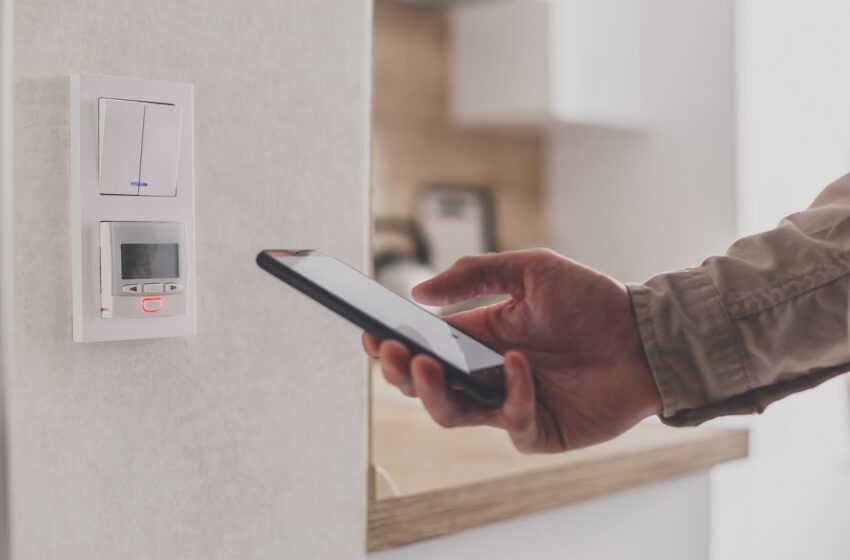 smartphone-connecting-to-floor-heating-controller-in-kitchen-remote-home-control-system-on-a-smartphone